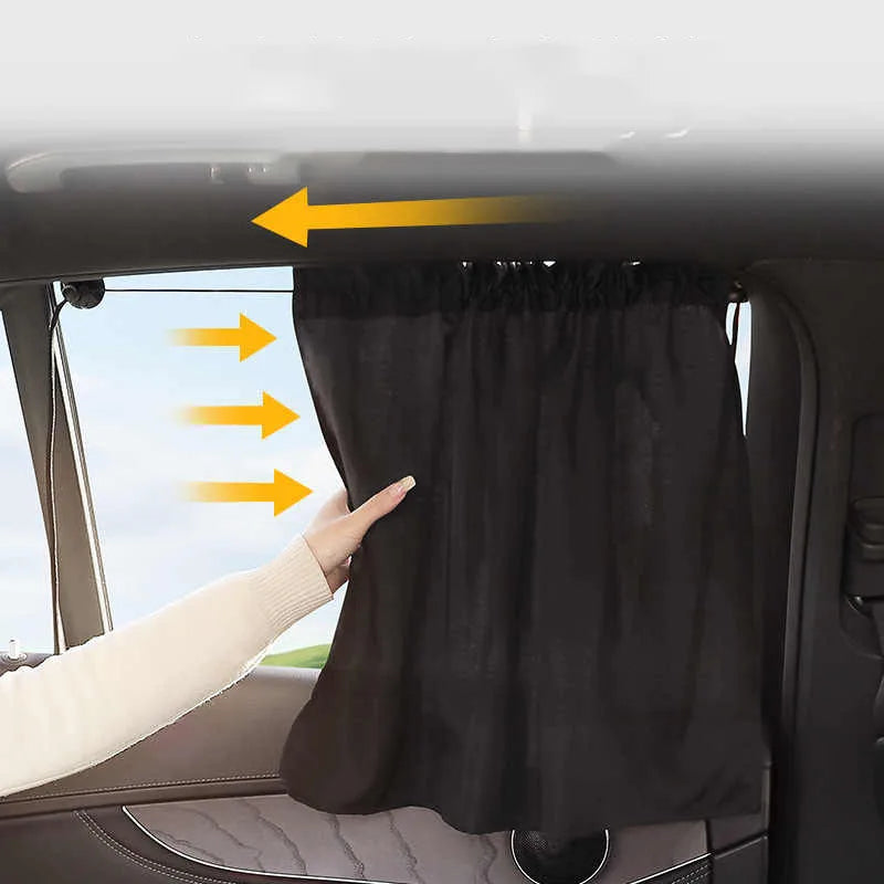 Car sunshade curtain with arrows indicating use, held by a hand inside a car.