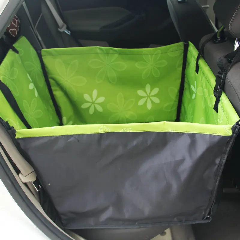 Green pet seat cover with floral pattern in a car