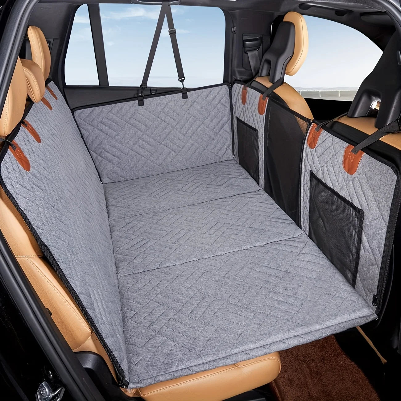 Car interior with a gray bench seat cover and pet barrier.