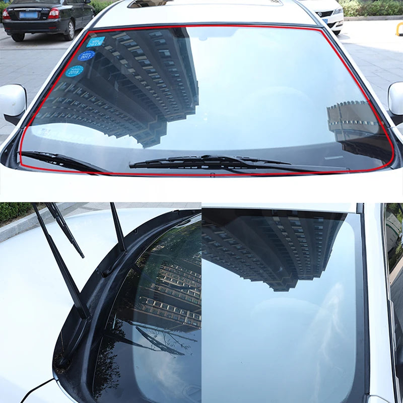 Car windshield with red border showing reflection of a building.