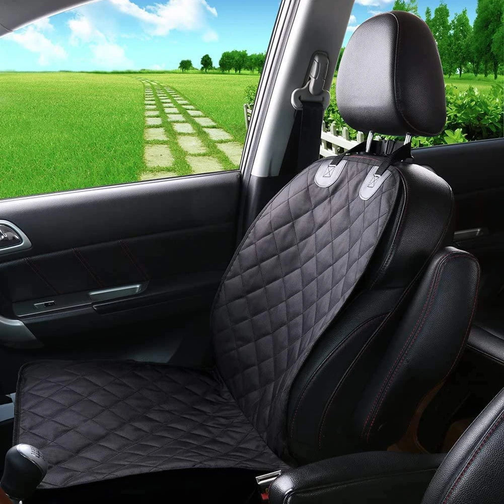 Car interior with black quilted seat covers and a scenic view outside the window.