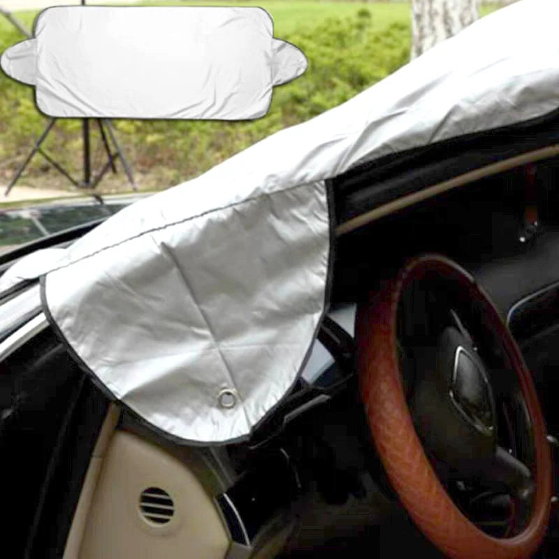 Car sunshade covering a car's windshield and dashboard with a blurred outdoor background.